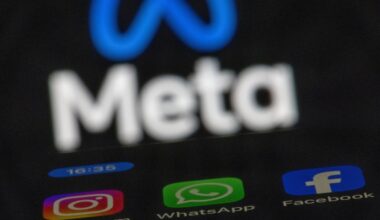The apps Instagram, Facebook and WhatsApp can be seen on the display of a smartphone in front of the logo of the Meta internet company.