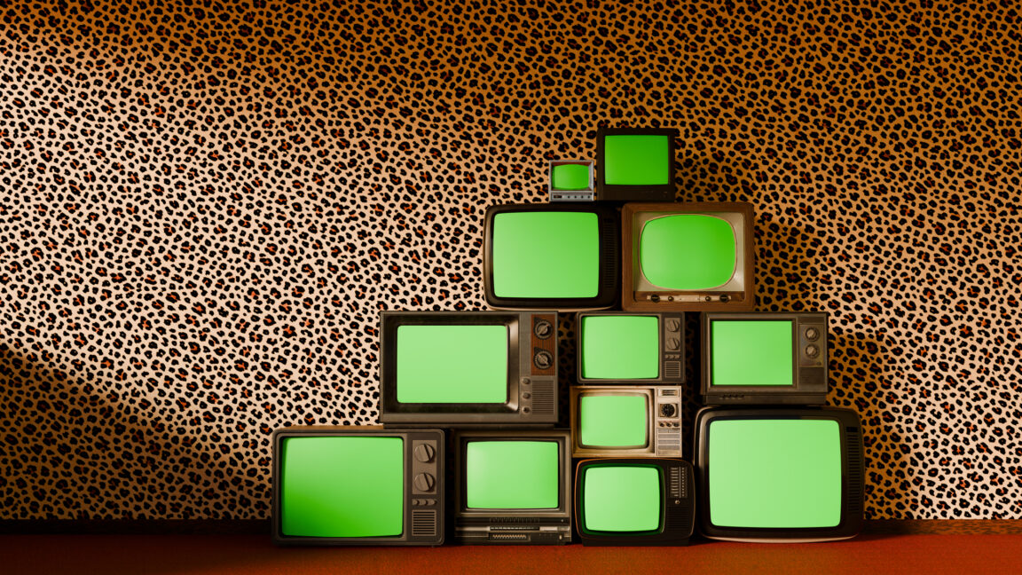 pyramid stack of vintage televisions, each with a vibrant green screen, set against bold leopard-patterned wallpaper and a luxurious red carpet floor.