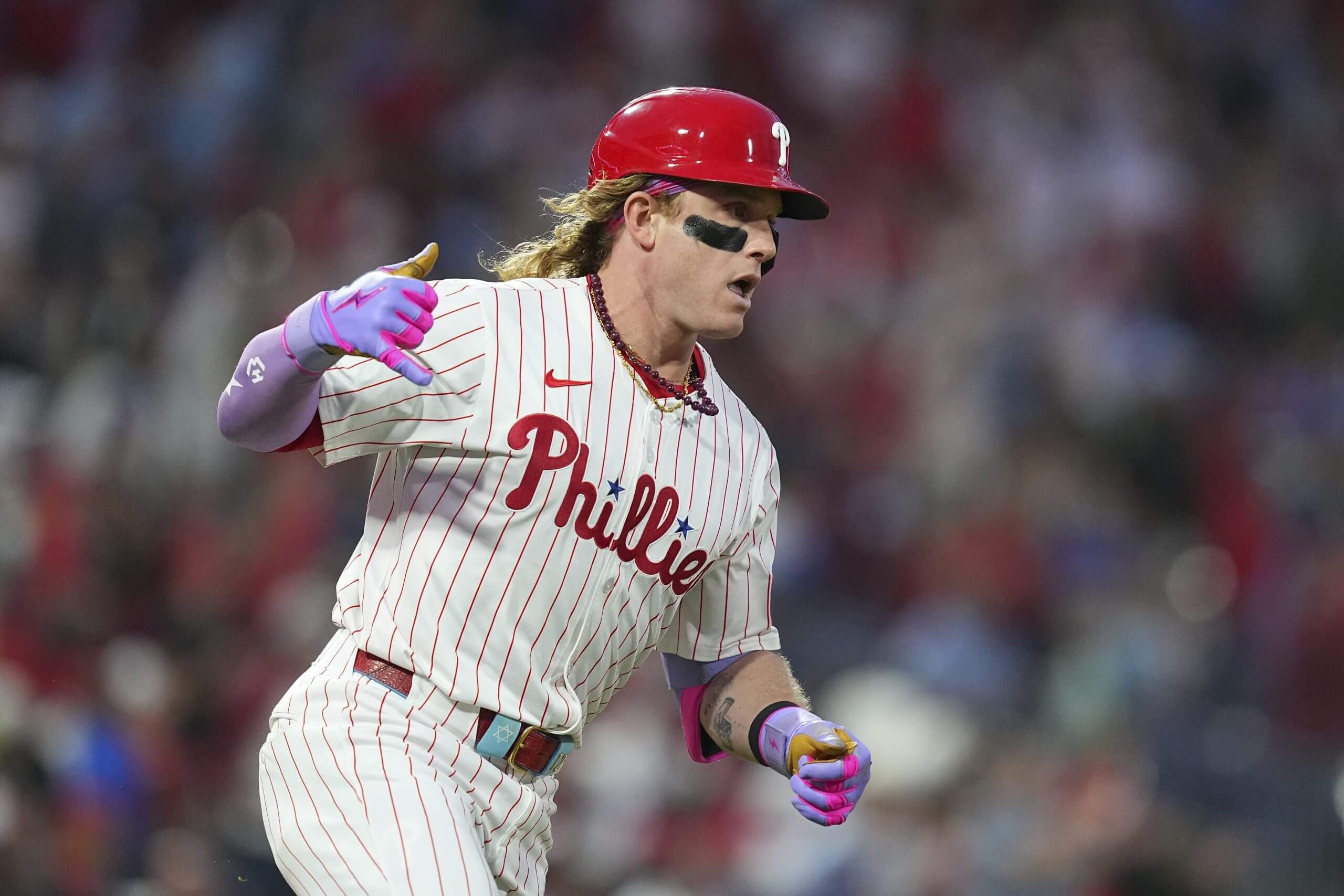 Harrison Bader holds his right hand up with his thumb and pinkie extended as he rounds the bases.