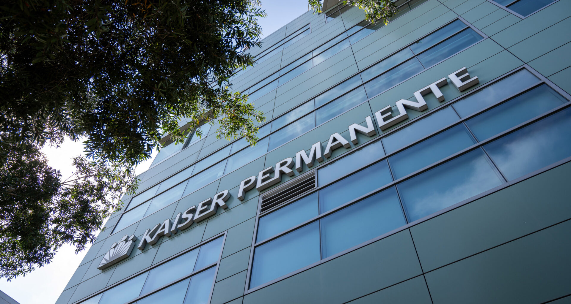 A photo of the Kaiser Permanente logo on the facade of a building.