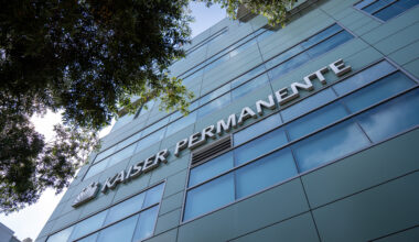 A photo of the Kaiser Permanente logo on the facade of a building.
