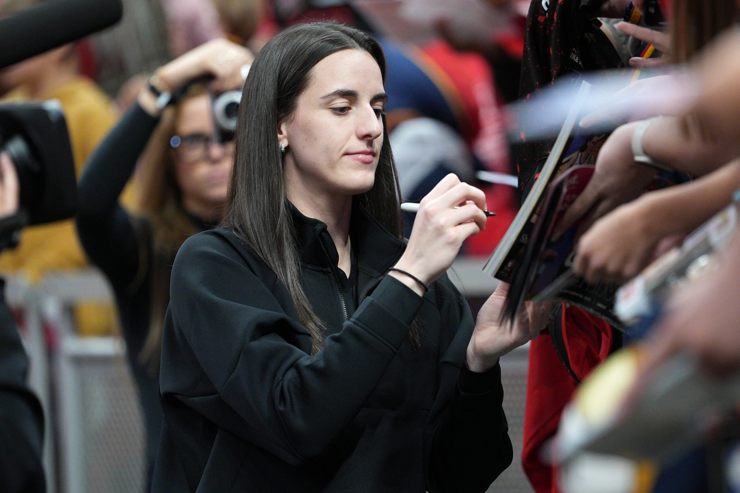 Caitlin Clark #22 of the Indiana Fever signs autographs before the game against the Las Vegas Aces during Round 2 Game 4 of the 2025 WNBA Playoffs