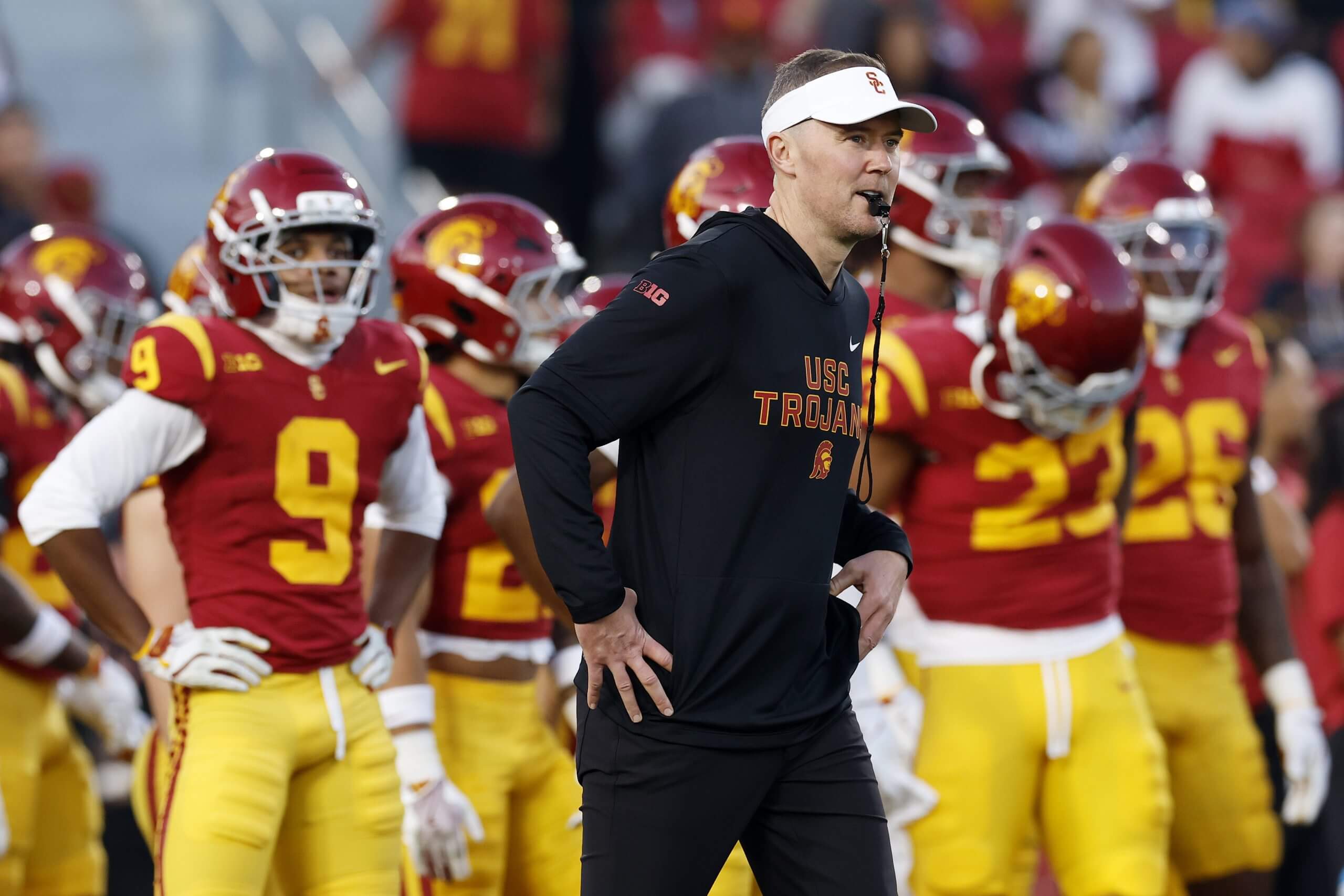 Coach Lincoln Riley looks on with a whistle in his mouth during USC warmups