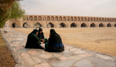 Women sit on a sidewalk along the dried-up riverbed of the Zayanderud in Isfahan, Iran, on Dec. 1, 2025. Credit: Hozi/Middle East Images/AFP via Getty Images
