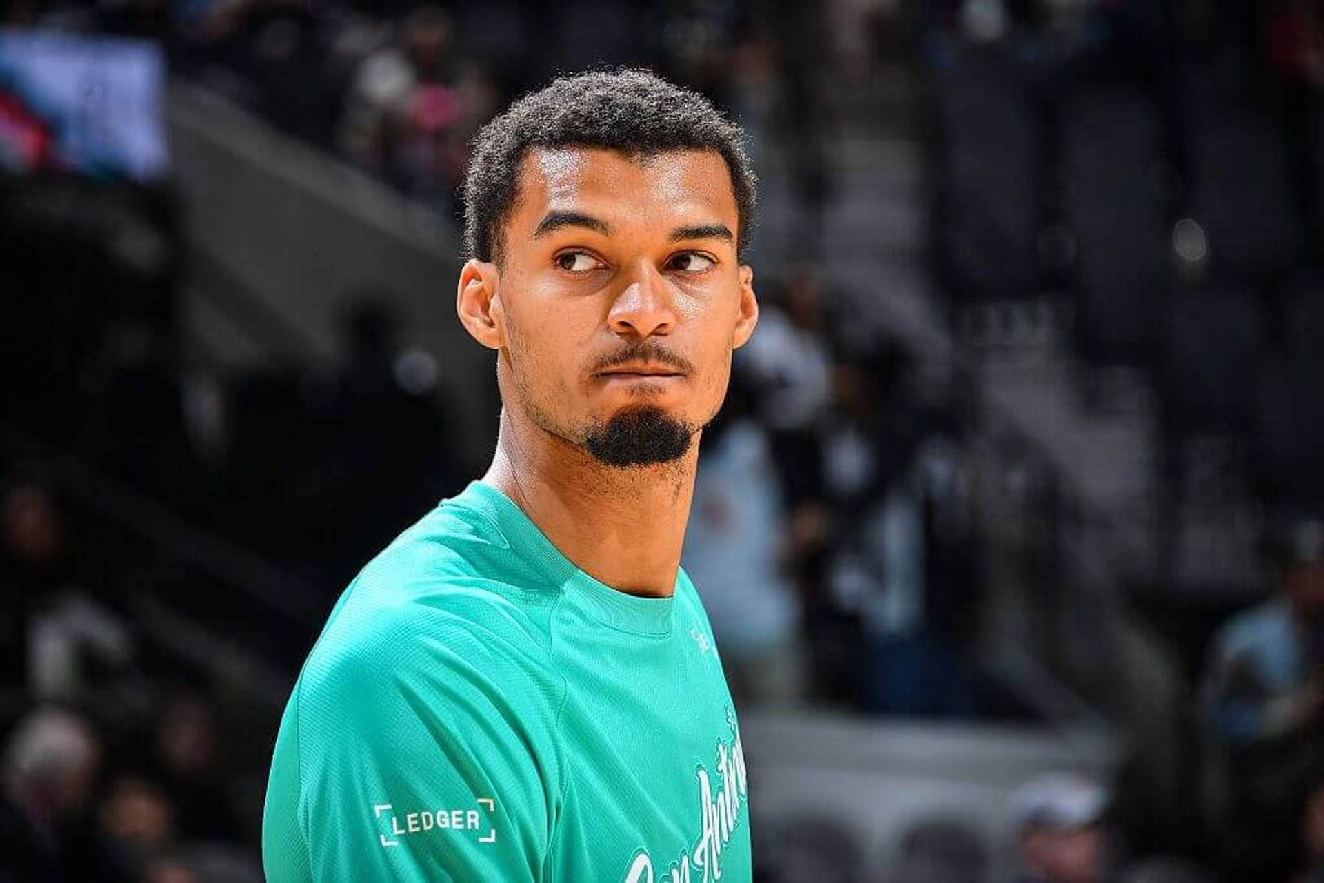 Victor Wembanyama looks on before a Spurs game.