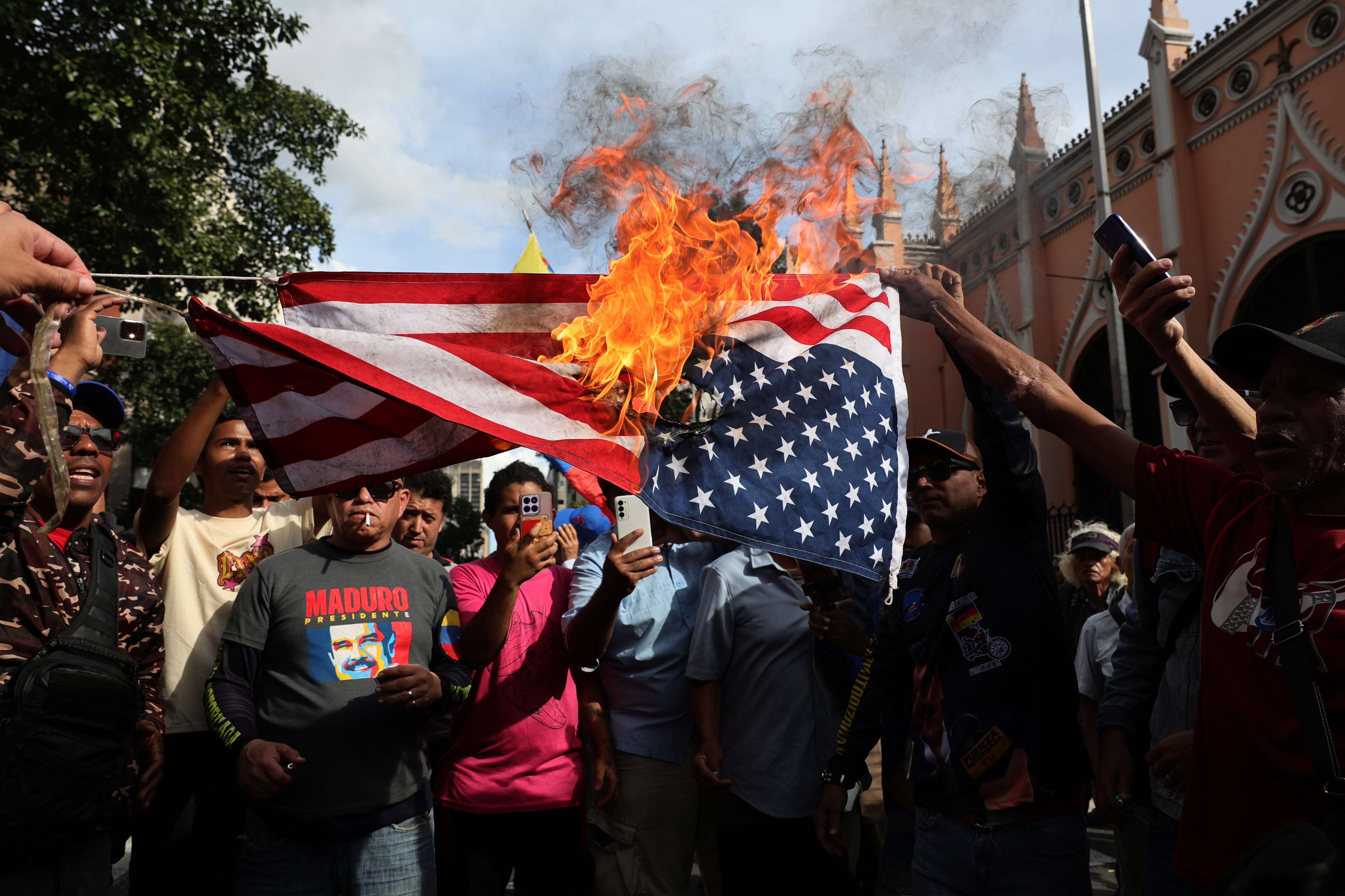 Maduro supporters set fire to an American flag in Caracas