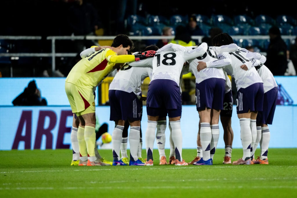 Manchester United players in huddle.