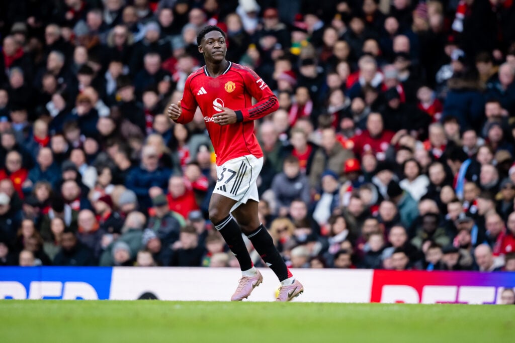 Kobbie Mainoo running in Manchester United kit.