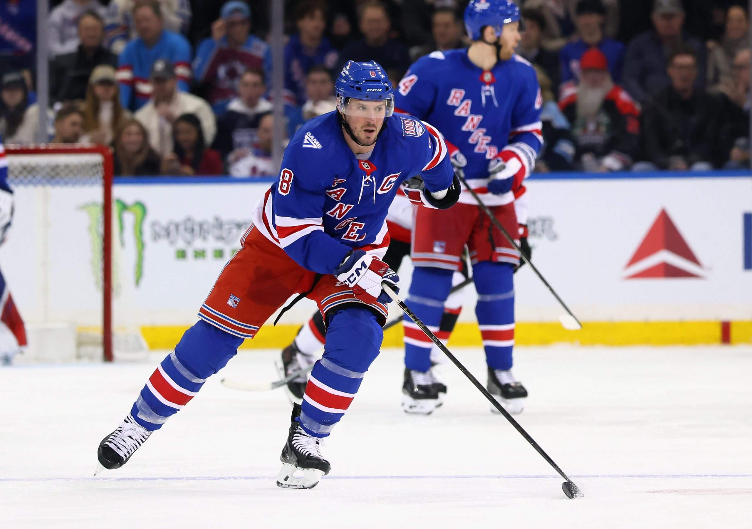 J.T. Miller skates down the ice with another Rangers teammate looking to the side behind him.