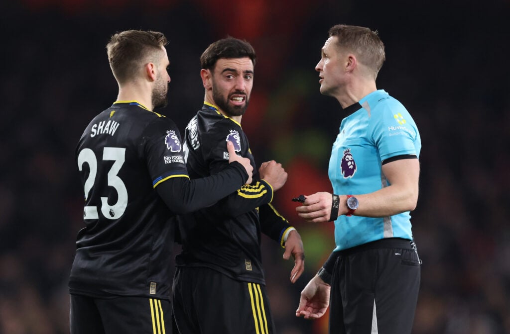Luke Shaw and Bruno Fernandes interact with referee Craig Pawson during the Premier League match between Arsenal and Manchester United at the Emirates Stadium in 2026 in London, England.