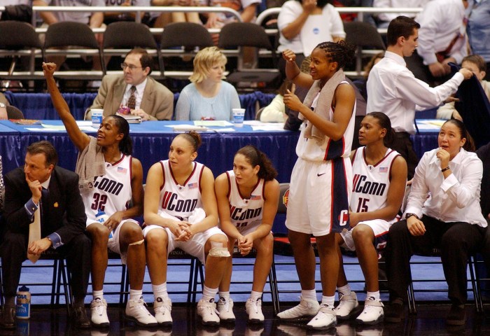 The 2002 UConn women's basketball starting five sit on the bench. From left to right: Swin Cash, Diana Taurasi, Sue Bird, Tamika Williams and Asjha Jones.