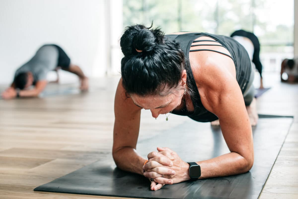 Woman practicing hot yoga holding plank pose