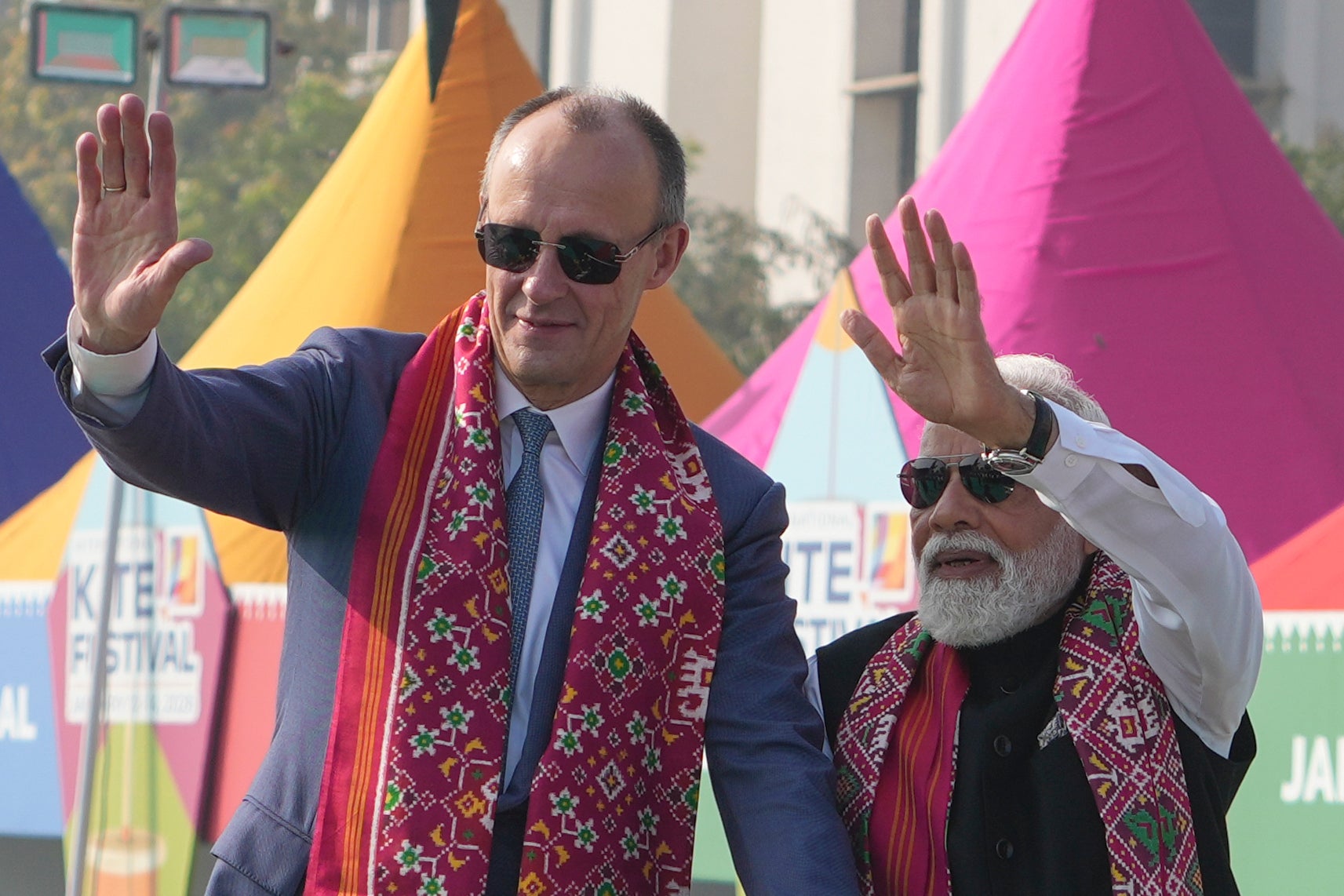 German chancellor Friedrich Merz and Indian prime minister Narendra Modi waves as they arrive for the inauguration of the International Kite Festival in Ahmedabad, India