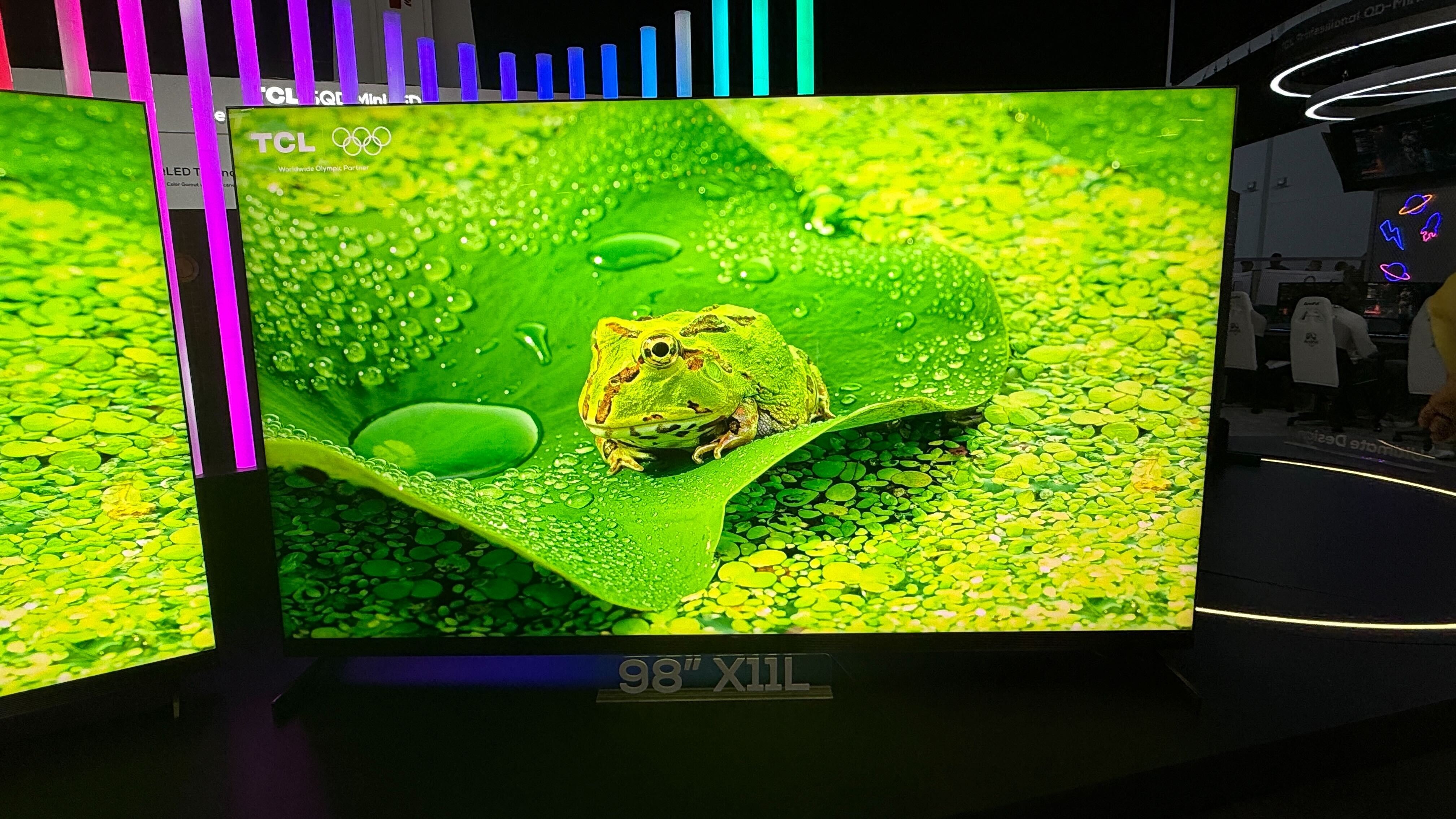 A large TCL TV with a frog on screen