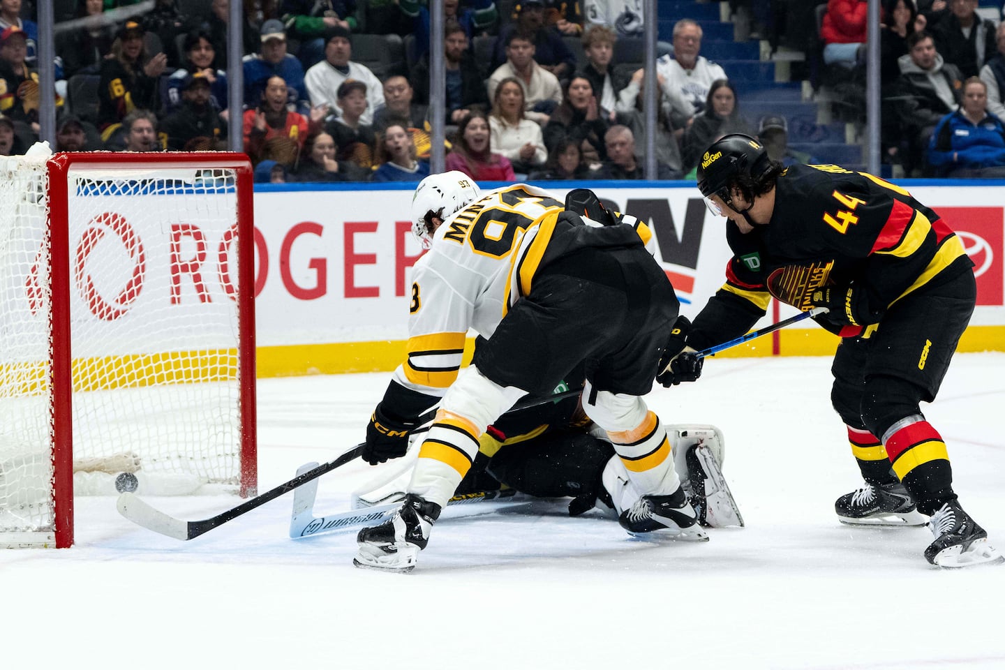 Fraser Minten (left) scores on goaltender Kevin Lankinen as Kiefer Sherwood defends during overtime.