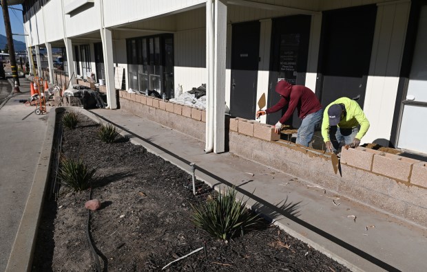 A crew works on raising a short wall in front of 475 Gate 5 Road in Sausalito, Calif., on Thursday, Jan. 15, 2026. Water from king tides earlier in the month flowed over the wall and into the building. (Alan Dep/Marin Independent Journal)
