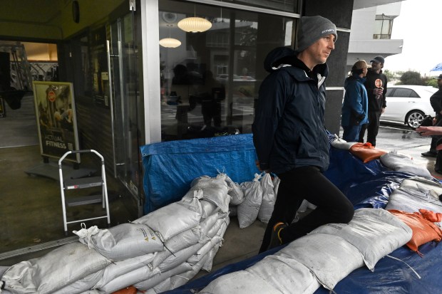 Ryan Davis, general manager of Fitness SF, discusses the king tides at the sandbagged entrance to the gym in Corte Madera, Calif., on Monday, Jan. 5, 2026. Despite the barrier, floodwater managed to get in the building over the weekend. (Alan Dep/Marin Independent Journal)