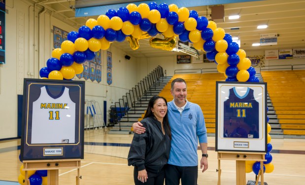 Former Marina High star Natalie Nakase, left, poses with current Vikings girls' basketball head coach Danny Roussel during a jersey retirement ceremony for Nakase in the Marina gym Jan. 18, 2024, in Huntington Beach. (Photo by Leonard Ortiz, Orange County Register/SCNG)