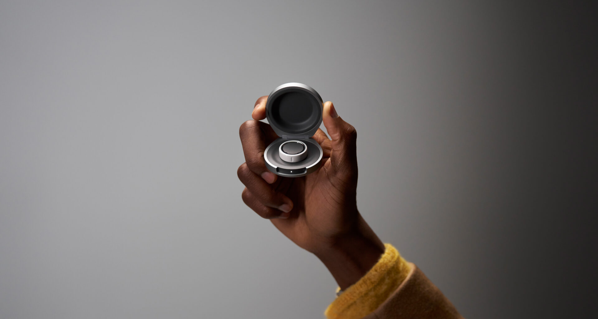 An Oura Ring user holds their Oura Ring Charging Case in hand.