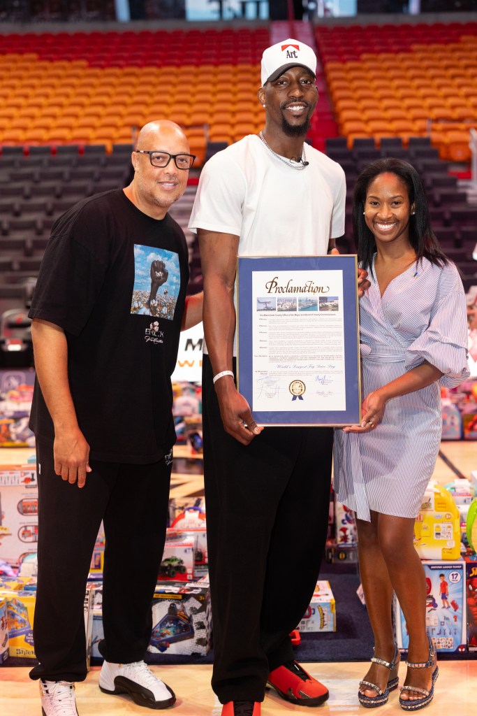 Bam Adebayo posing for a photo with two others.