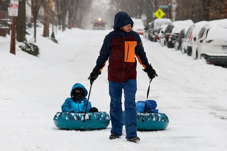 David Friedman (center) pulls his sons Noah, 5, (left), and Zachary, 3, along South Third Street in Society Hill. This was the heftiest snow since February 2021.