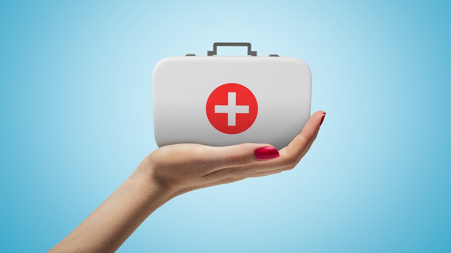 Side closeup of woman's hand facing up and holding small medical bag on light blue gradient background.