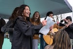 Viola DeVigal, an organizer and leader of the demonstration, left, sings protest songs with Leone Cook, center, and others at a rally of mostly high school students who walked out of class or didn’t attend as part of a general strike in protest of recent U.S. immigration policies, violence and killings, at Glenhaven Park in Portland Ore., on Jan. 30, 2026.