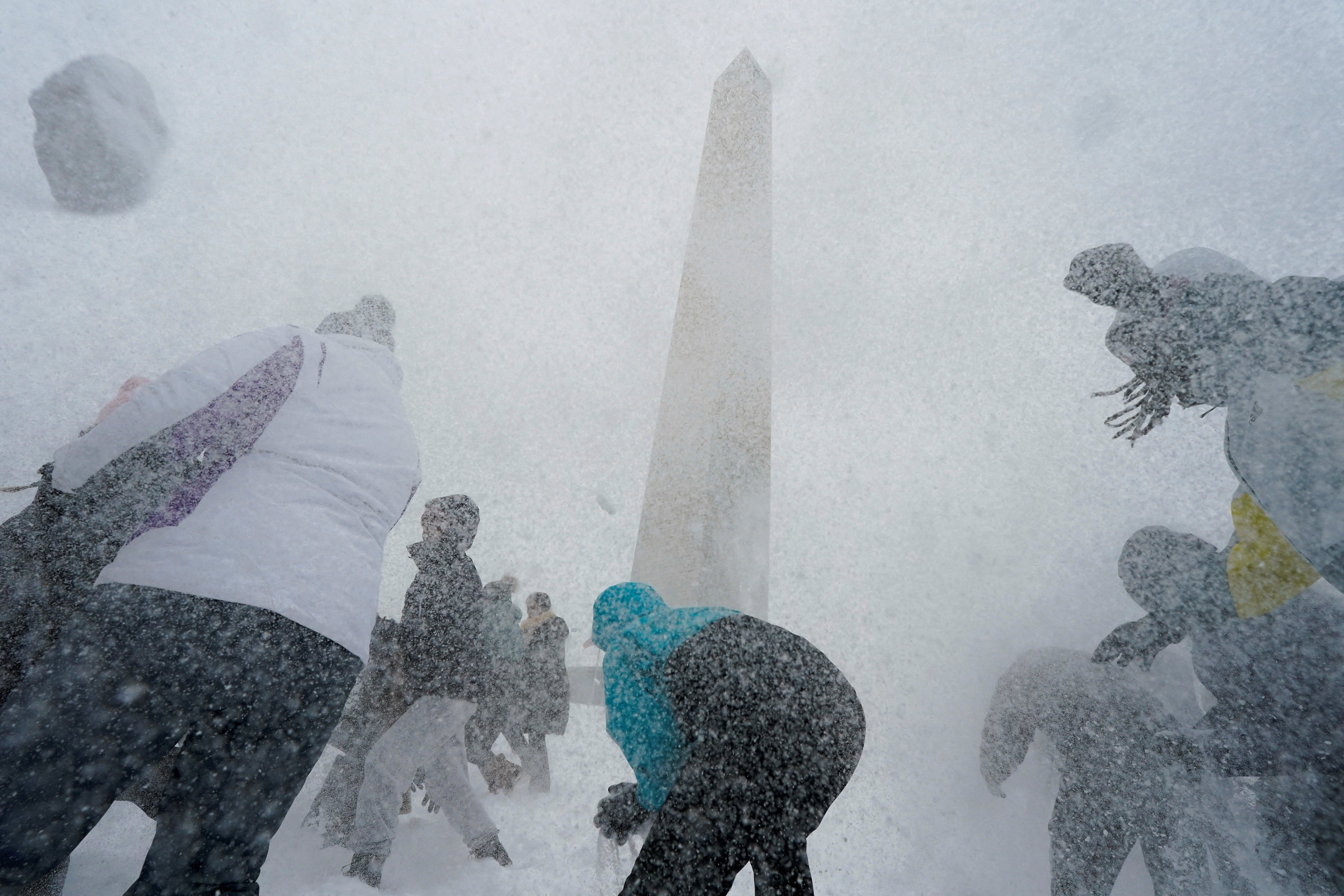 People play with snowballs by the Washington Monument during snowfall, as a major winter storm spreads across a large swath of the United States, in Washington, D.C., U.S., January 25, 2026.