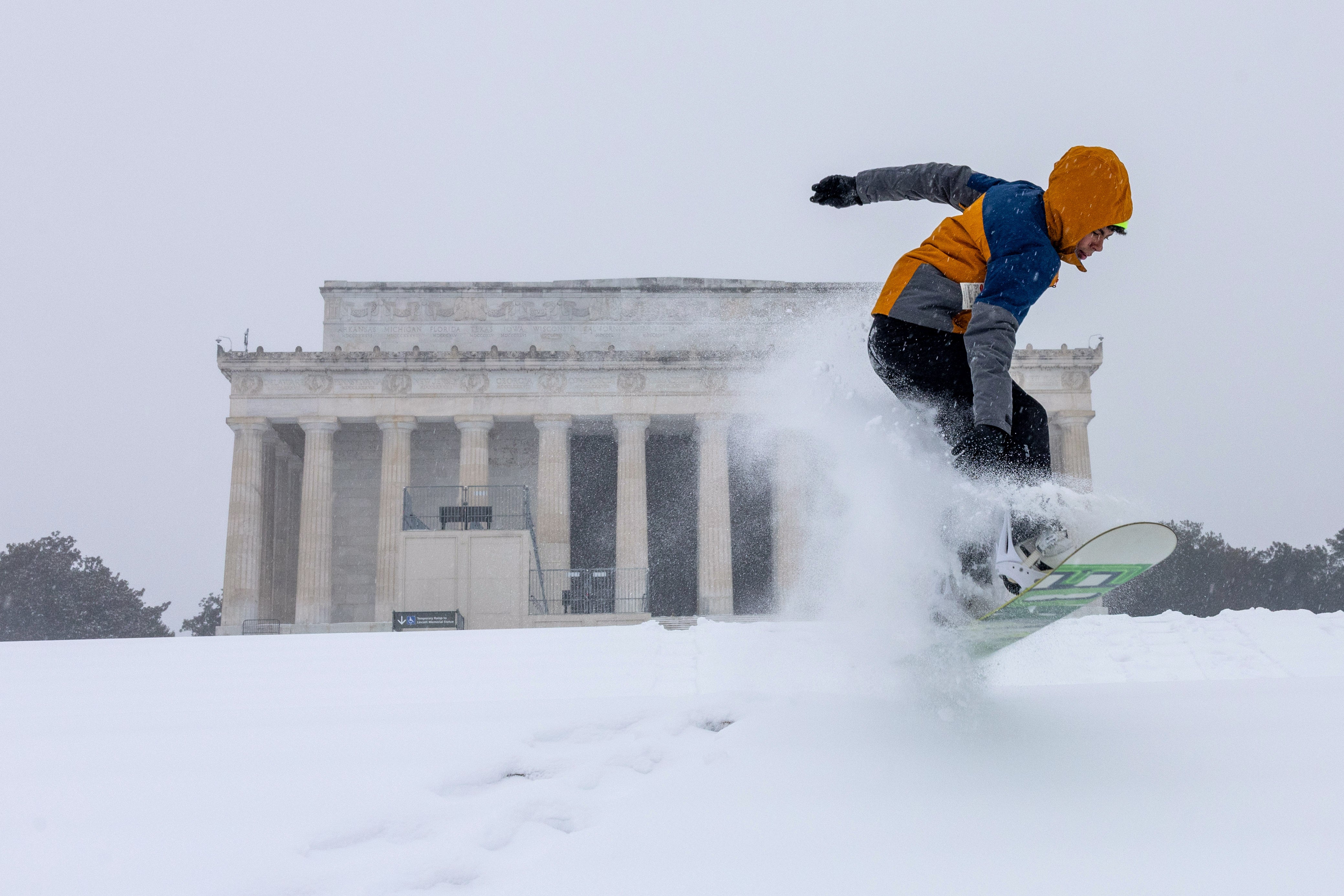 Jonnie Plass snowboards on the stairs near the Lincoln Memorial on January 25, 2026 in Washington, DC. A massive winter storm is bringing frigid temperatures, ice, and snow to nearly 200 million Americans from Texas to New England.