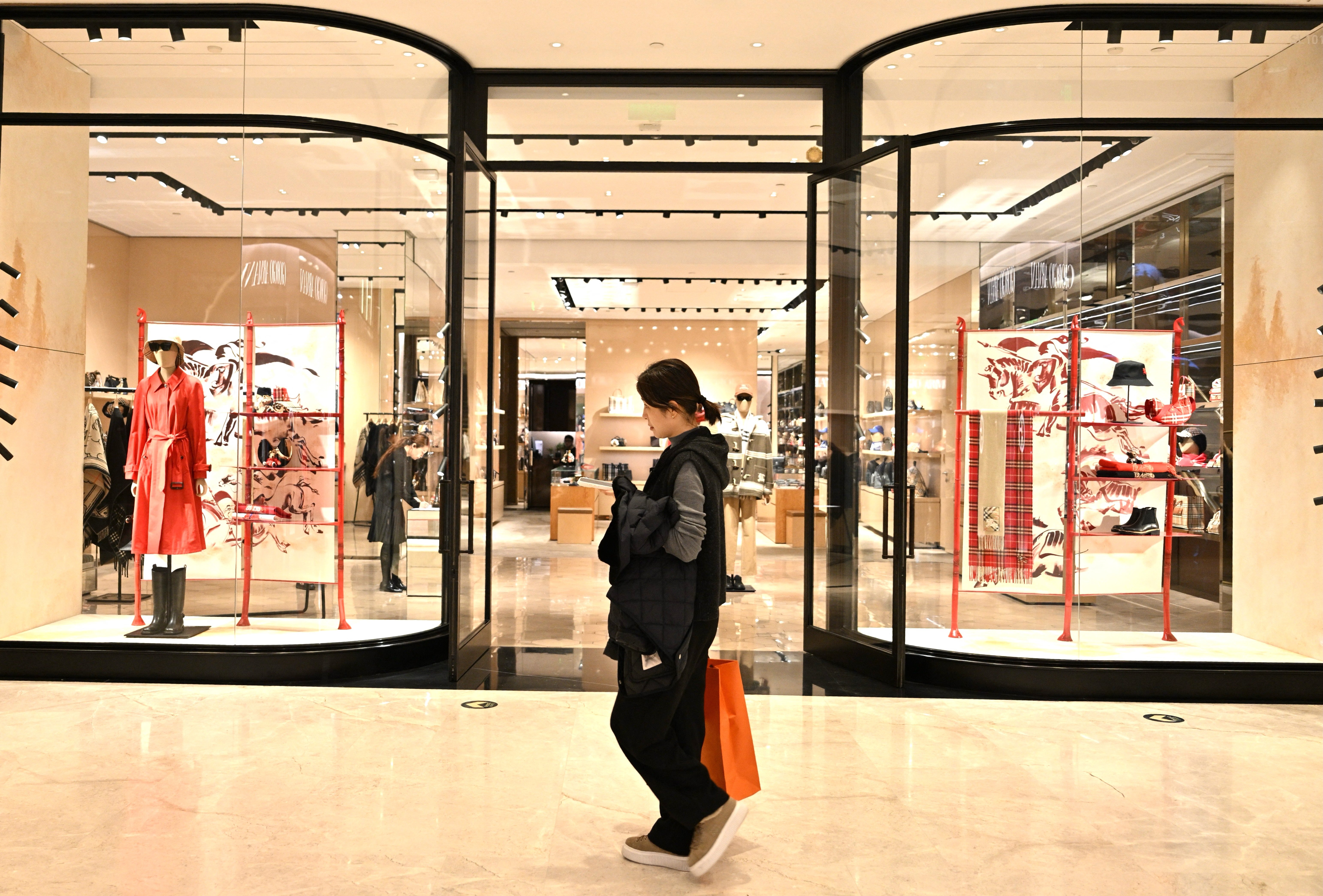 A woman walks past a British Burberry shop at a shopping mall in Beijing on January 30, 2026. (Photo by ADEK BERRY / AFP via Getty Images)