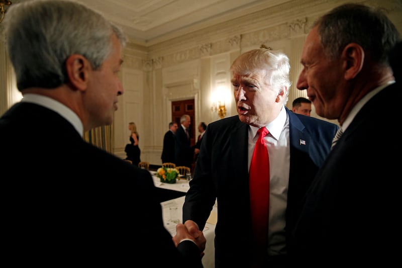 FILE PHOTO: U.S. President Donald Trump shakes hands with JPMorgan Chase & Co CEO Jamie Daimon (L) as he hosts a strategy and policy forum with chief executives of major U.S. companies at the White House in Washington February 3, 2017.  REUTERS/Kevin Lamarque/File Photo