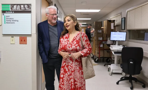 Tim Williams and his wife, Sara Williams, visit Delray Medical Center in Delray Beach, Friday, Jan. 2, 2026. Williams, the director of the hospital's proton therapy center, became a patient there after collapsing at home. He survived a stroke, nine days in a coma, an in-bed surgery and a long recovery. (Carline Jean/South Florida Sun Sentinel)