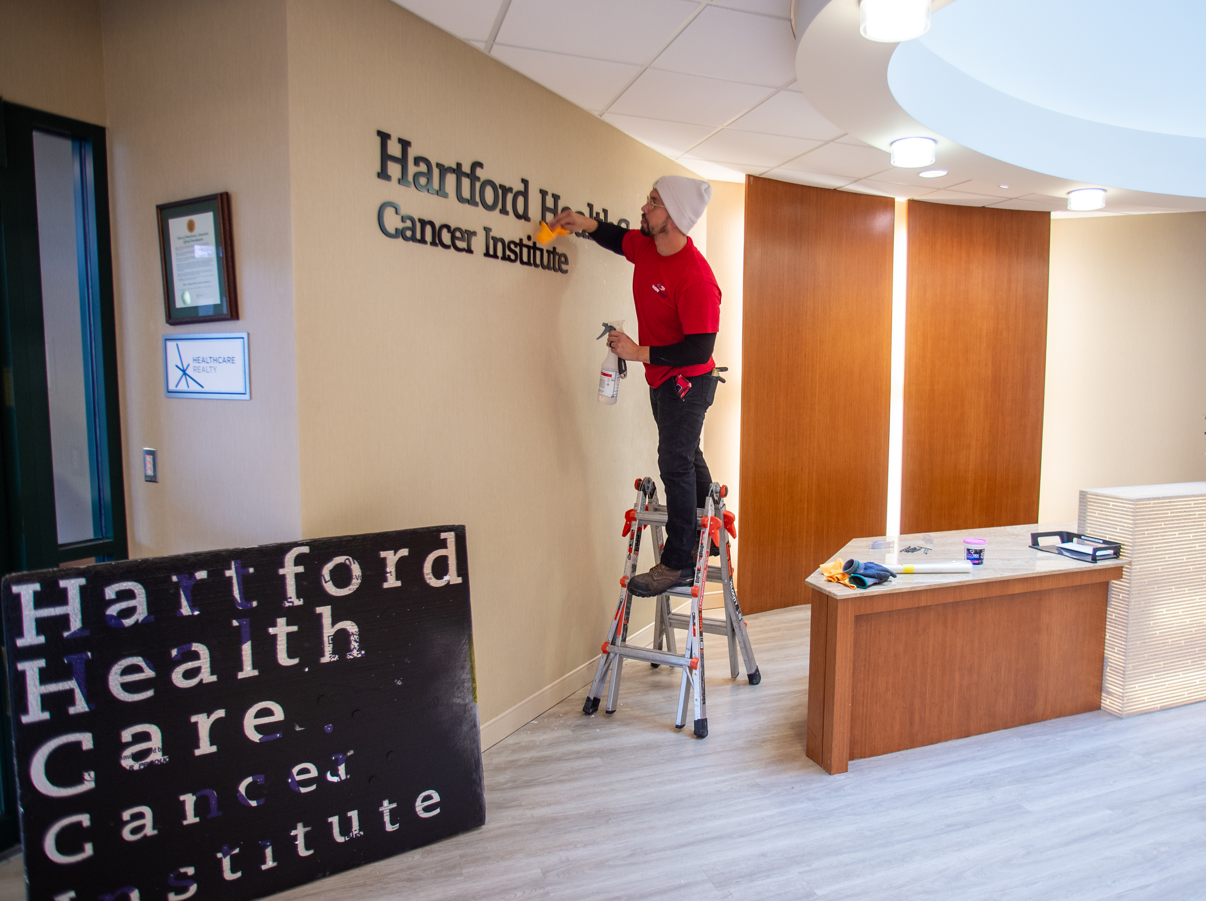 Emmanuel Rivera of Sign Pro hangs a new Hartford HealthCare...