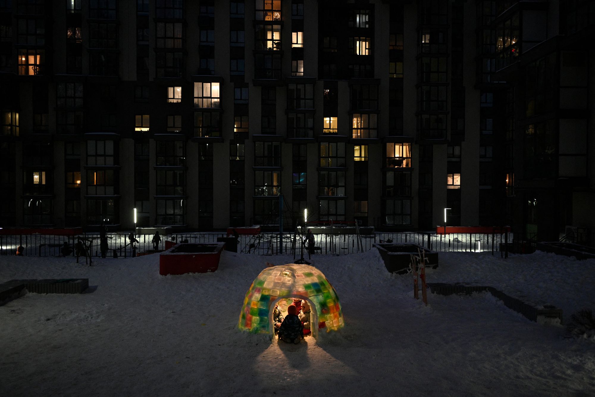 Children play inside an ice igloo built by local residents in the courtyard of a residential building in Lviv