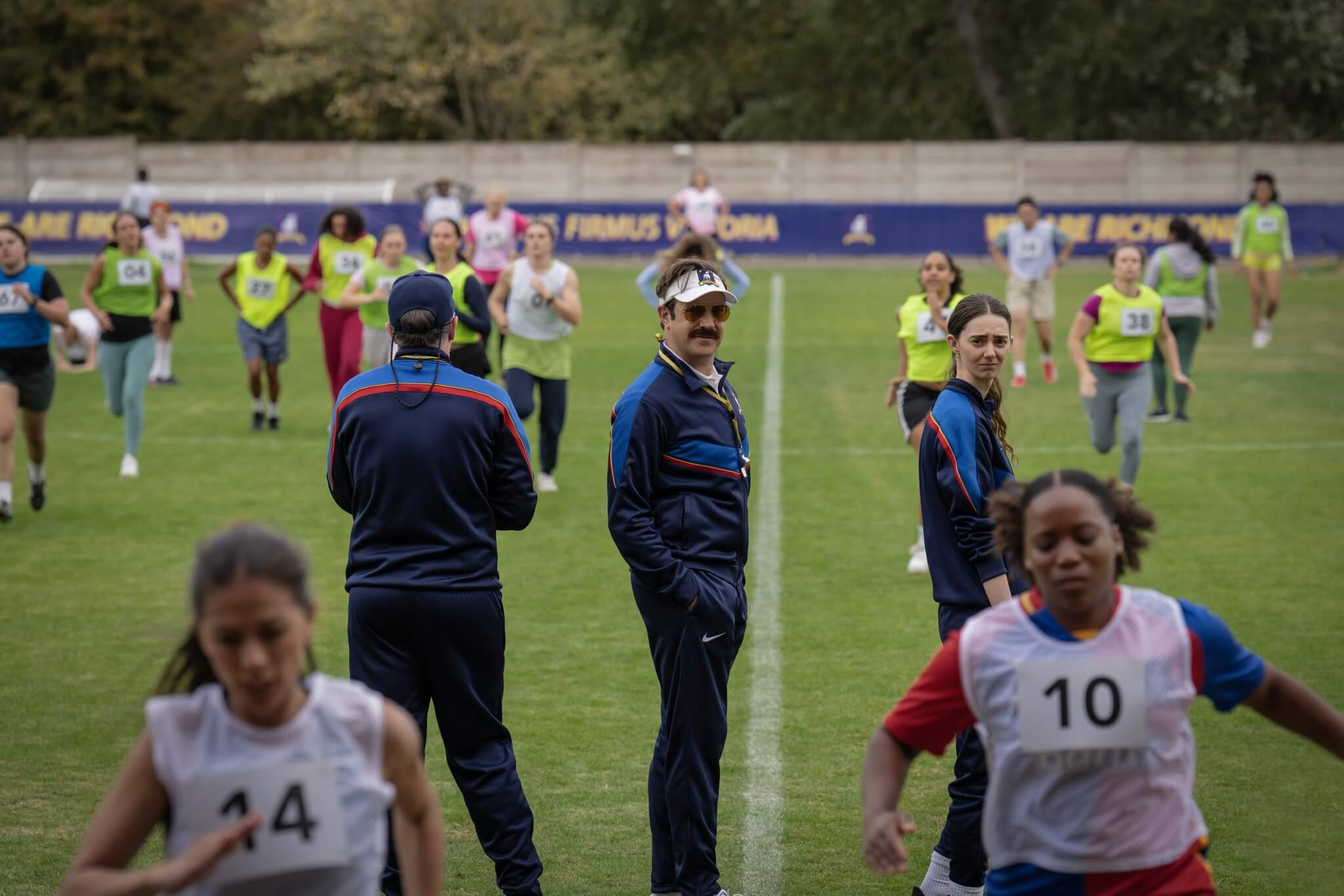 Jason Sudeikis as Ted Lasso on the field coaching his team