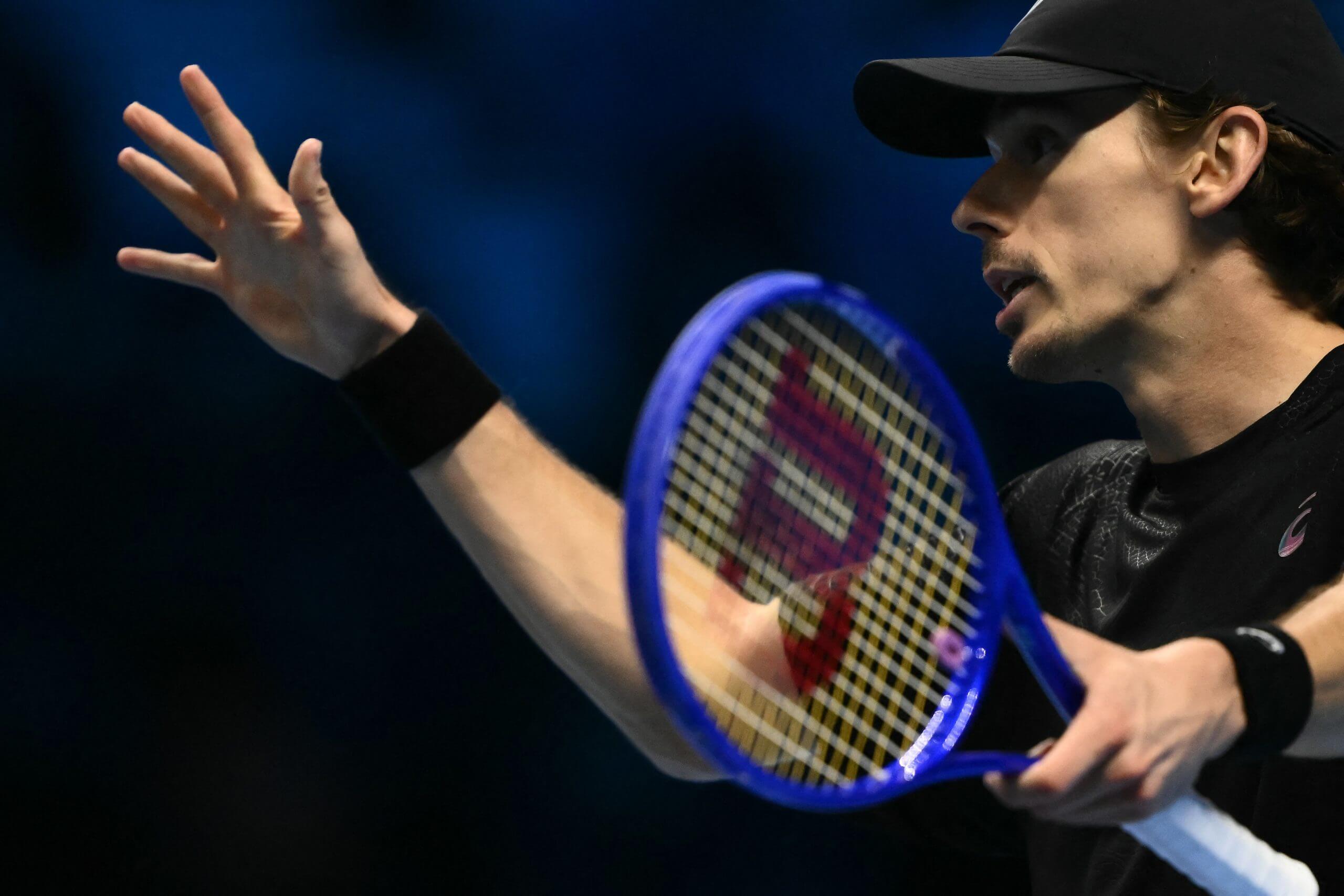 Alex de Minaur gestures in frustration holding his tennis racket in his left hand.