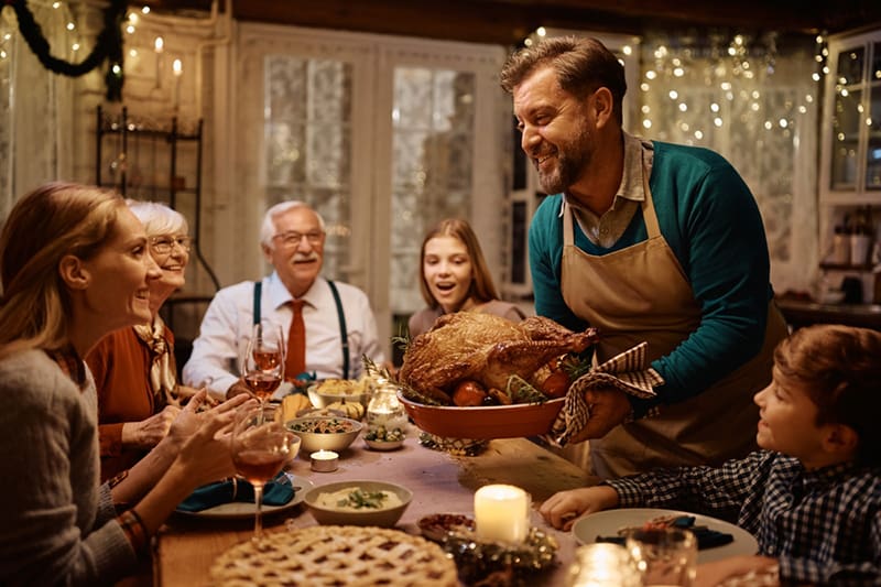 A multi-generational family gathers around a warmly lit dinner table, reflecting the faith, family values, and meaningful stories Meridian readers engage with globally.