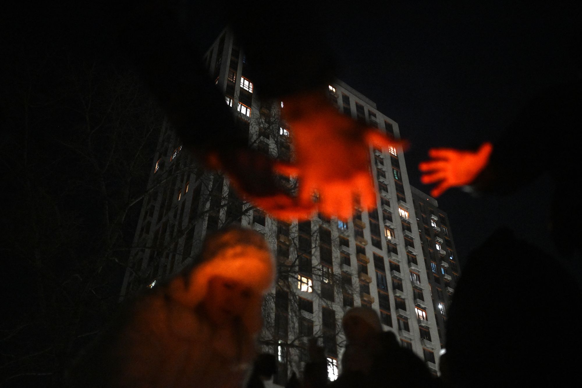Local residents gather around a bonfire during an outdoor party to keep warm as many apartments remain without heating in Kyiv
