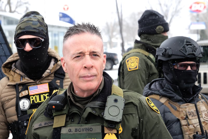 US Customs and Border Patrol Commander Gregory Bovino stands in a gas station parking lot in Minneapolis