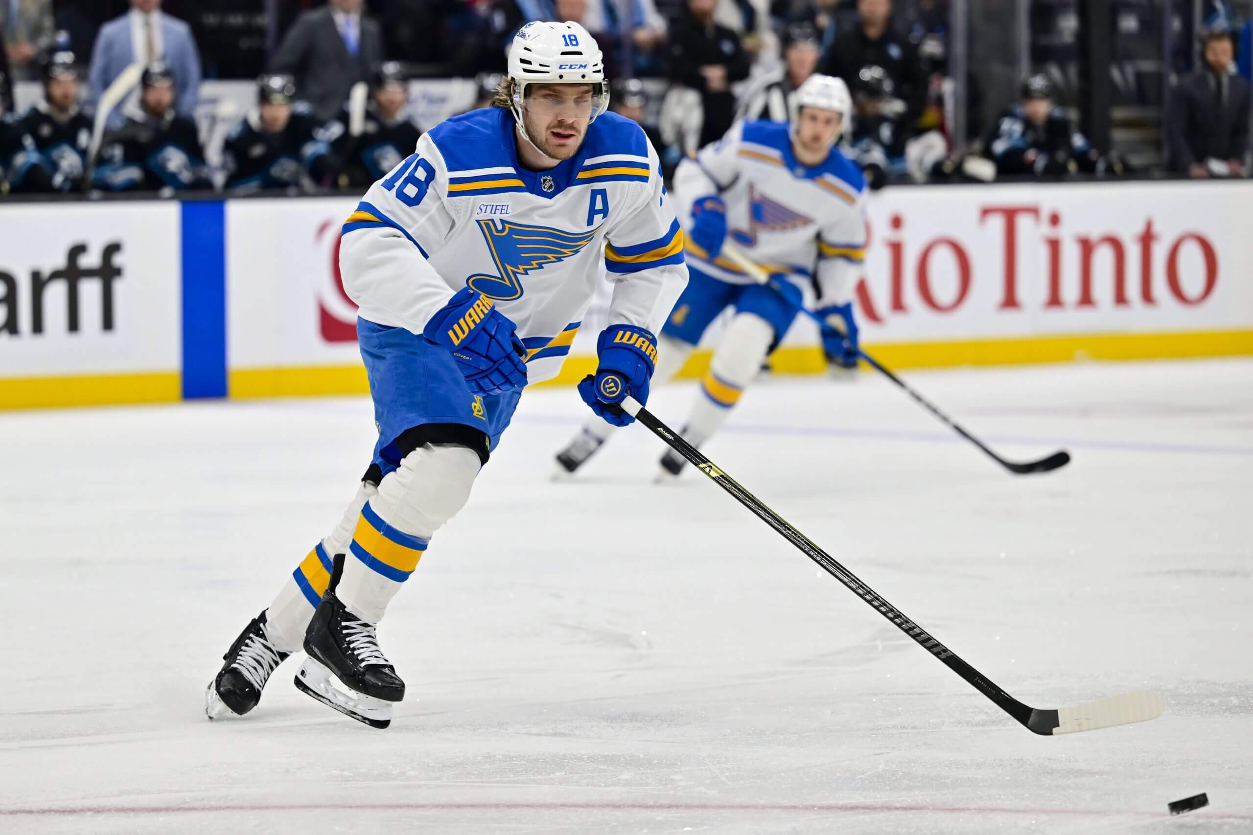 Robert Thomas skates with the puck during a Blues game with a teammate in the distance.