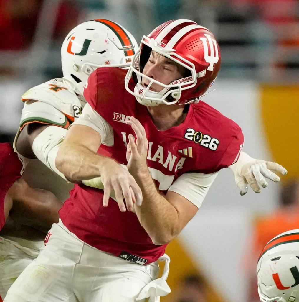 Miami (FL) Hurricanes defensive lineman Rueben Bain Jr. (4) wraps up Indiana Hoosiers quarterback Fernando Mendoza (15) on Monday, Jan. 19, 2026, during the College Football Playoff National Championship college football game at Hard Rock Stadium in Miami Gardens.