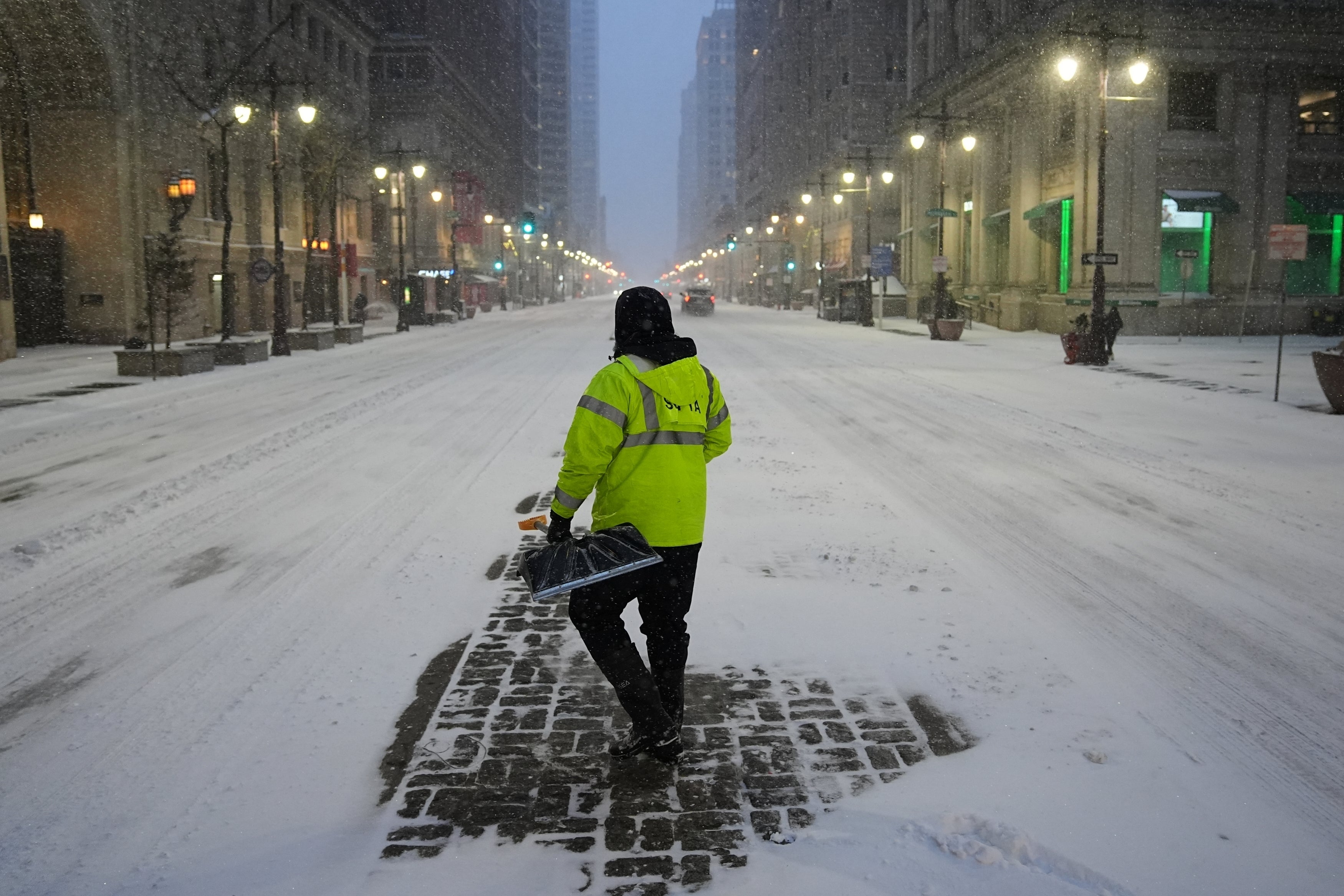 A worker shovels snow during a winter storm in Philadelphia, Sunday, Jan. 25, 2026.
