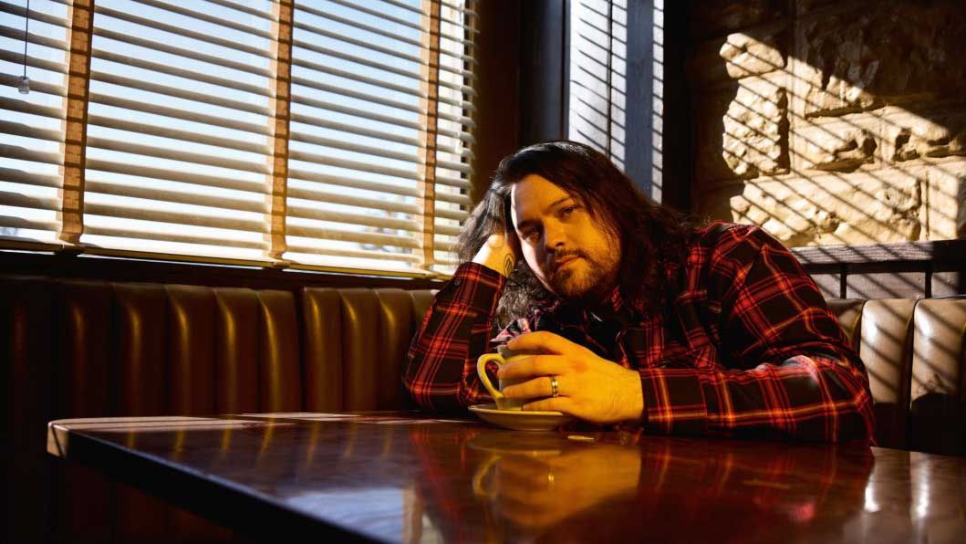 Wolfgang Van Halen in a diner booth, drinking coffee