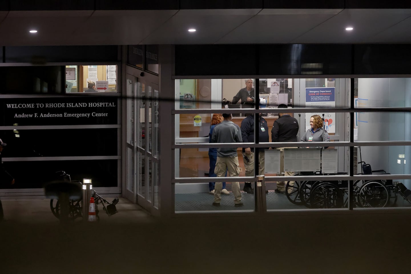 People stood at an entrance to Rhode Island Hospital in Providence on Dec. 13, where victims from a shooting at Brown University were transported.