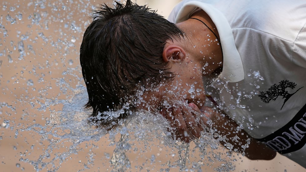 FILE - A boy cools himself in a fountain on a hot day in Moscow, Russia, July 9, 2025.