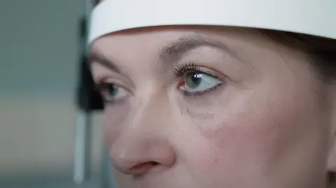 Nicki stares straight ahead while her eyes are being examined during a check up