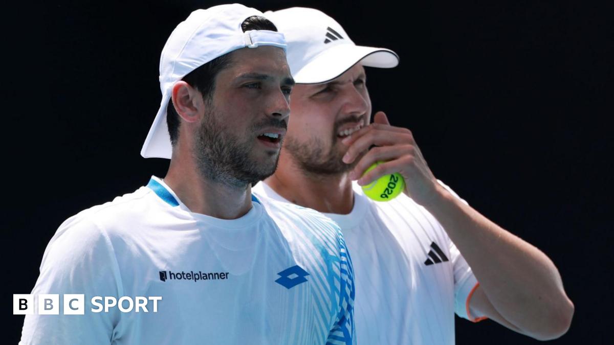 Julian Cash and Lloyd Glasspool discuss tactics during their Australian Open second-round match