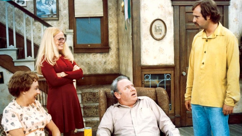 Edith, Gloria, and Archie laughing in Meathead's direction in All In The Family