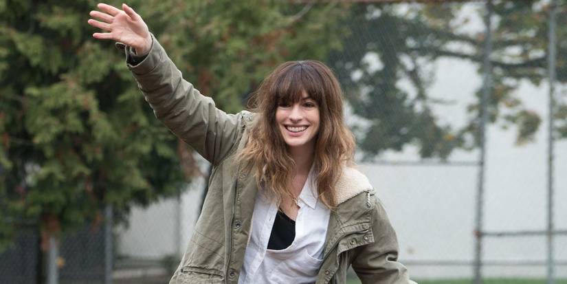Anne Hathawy as Gloria waving and smiling in Colossal