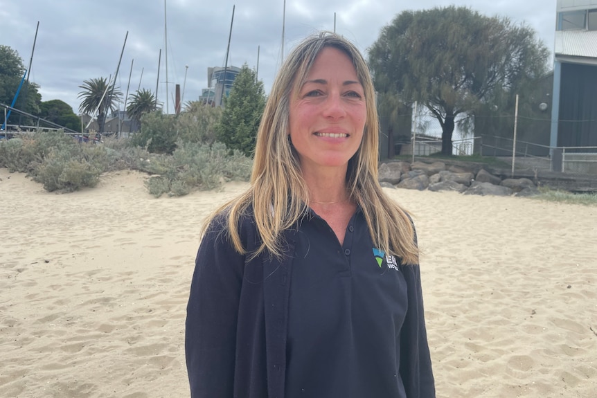 A woman standing on a beach, smiling
